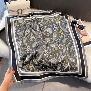 Detail of vintage paisley silk scarf with olive green pattern on plush background