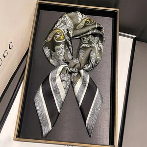 Detail of dark green paisley and black-white striped silk scarf in elegant knot tie style