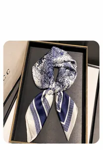 Close-up of 70cm satin silk scarf with blue Toile de Jouy print and striped border