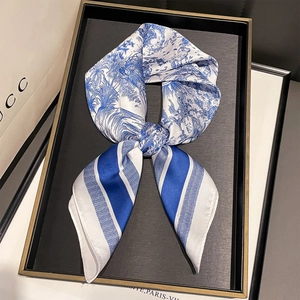 Detail of blue and white Toile de Jouy silk scarf with stripe patterns on display tray