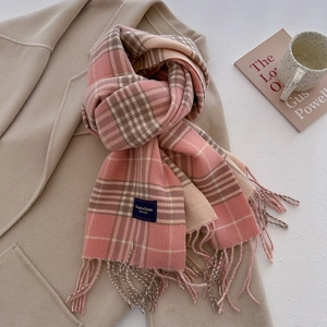Detail van zachte geruite sjaal met franjes en Elegant & Classic label in de winter