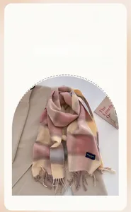 Close-up of pink and beige plaid scarf with fringed edges and soft cashmere texture
