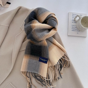 Detail of plaid tassel scarf texture with woven label on a beige coat background