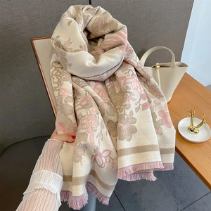 Écharpe élégante à fleurs avec pompons roses drapée sur une chaise au style chic