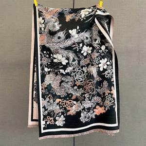 Détail de jacquard floral et phénix avec finitions à franges sur une écharpe épaisse