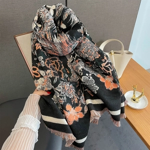 Détail du motif jacquard floral phoenix et des franges à glands sur l'écharpe d'hiver