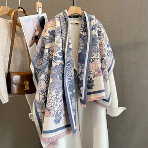 Détail de l'écharpe jacquard à fleurs phénix avec glands roses sur un manteau blanc