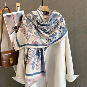 Détail de l'écharpe en jacquard floral avec franges sur un manteau d'hiver beige