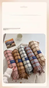 Detail view of colorful plaid scarves with elegant classic labels and soft fringe edges