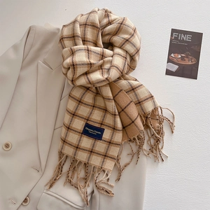 Close-up of beige and brown checkered scarf with fringe and Elegant & Classic label