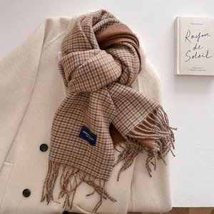 Detail of vintage plaid tassel scarf showing woven texture and elegant brand label