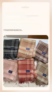 Detail of soft cashmere-like plaid scarves with elegant tassels in various colors