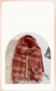 Detailed view of red and beige checkered scarf with tassel fringe on a wool coat