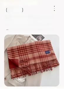 Close-up of red plaid cashmere scarf with tassel edges and Elegant Classic label detail