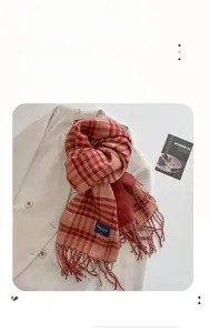 Close-up of red and beige checkered cashmere scarf with fringe and woven brand label