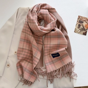 Detailed close-up of pink and brown plaid cashmere scarf with soft tassels and elegant tag