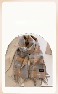 Detail of plaid scarf with tassels and Elegance Classic label on beige coat