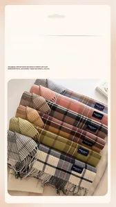 Close-up of the elegant soft fringe tassels and classic woven label on checkered scarf