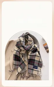 Detail of plaid cashmere-like scarf with fringe edges and elegant woven label