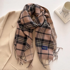 Macro shot of classic plaid cashmere scarf texture with tassels on wool coat