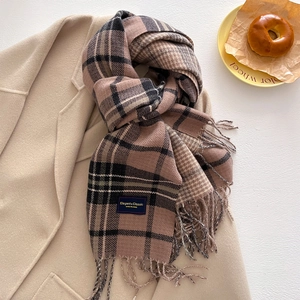 Detailed texture of autumn cashmere-feel scarf with retro plaid patterns and soft tassels