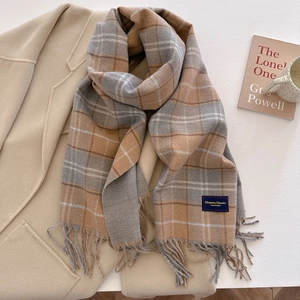 Classic checkered wool scarf for women with fringe on an elegant beige winter coat