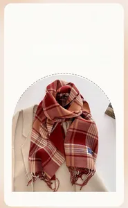 Close-up of thick checkered pashmina scarf with fringe details on beige coat