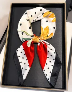Close-up of elegant faux silk scarf with geometric dot prints in a black gift box