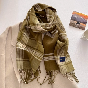 Classic green and beige plaid cashmere scarf with fringes on beige wool coat background