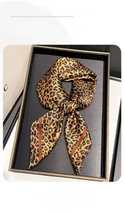 Close-up of leopard print satin scarf with glossy finish on a decorative black tray