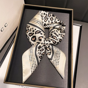 Elegant leopard print and polka dot satin square scarf on a luxury display tray