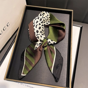 Detail of silk-like leopard print scarf featuring green and brown twill patchwork