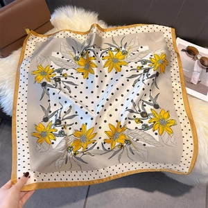 Close-up of silk-feel square scarf with yellow floral print and black polka dots