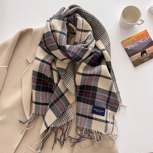 Classic checkered cashmere-feel scarf with tassels styled on a beige coat for winter fashion