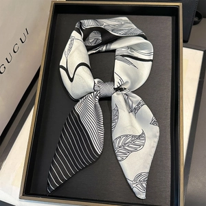 Macro detail of silk-feel twilly scarf with black and white abstract leaf patterns