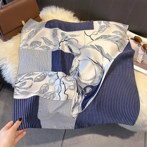 Detail of silk-feel square scarf with navy blue horse pattern and realistic leaf motifs