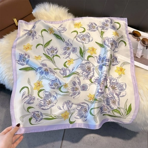 Detail of elegant floral satin square scarf with purple tulip print on white faux fur