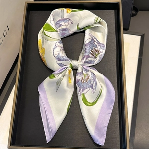 Close-up of silk scarf with purple tulip patterns on a black display tray