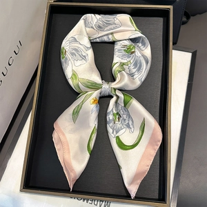 Elegant silk scarf with purple tulip print and pink borders on a display box