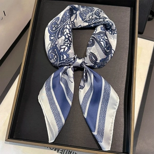 Detailed close-up of a blue and white satin neckerchief with paisley and striped patterns