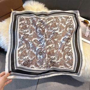 Detail of elegant paisley silk scarf with striped borders on a soft fur backdrop