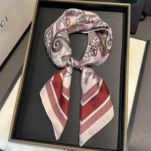 Macro detail of silk square scarf with paisley pattern and red geometric stripes