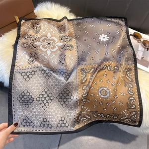 Detailed view of square silk scarf with paisley and star geometric patchwork patterns