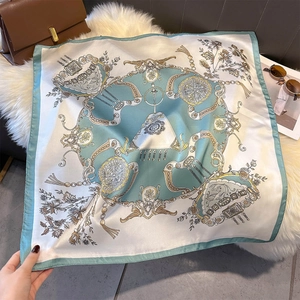 Close-up of mint green silk scarf with vintage equestrian patterns on faux fur carpet
