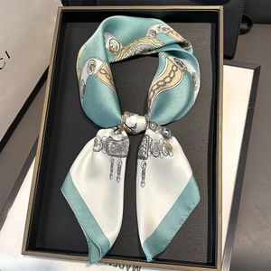 Detailed shot of a vintage pattern silk twilly scarf tied in a bow on a display box