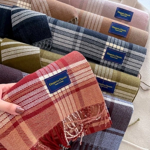 Stacked variety of colorful plaid scarves with long tassels in soft faux cashmere fabric