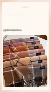 Detailed close-up of plaid cashmere-like scarves with tassel fringe in various warm colors