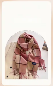 Close-up of pink and brown plaid cashmere-feel scarf with elegant woven label detail