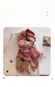 Detail of pink and brown plaid scarf with fringe showing thermal fiber knit texture
