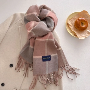 Detail of pink and grey checkered cashmere-feel scarf with tassels on wool coat